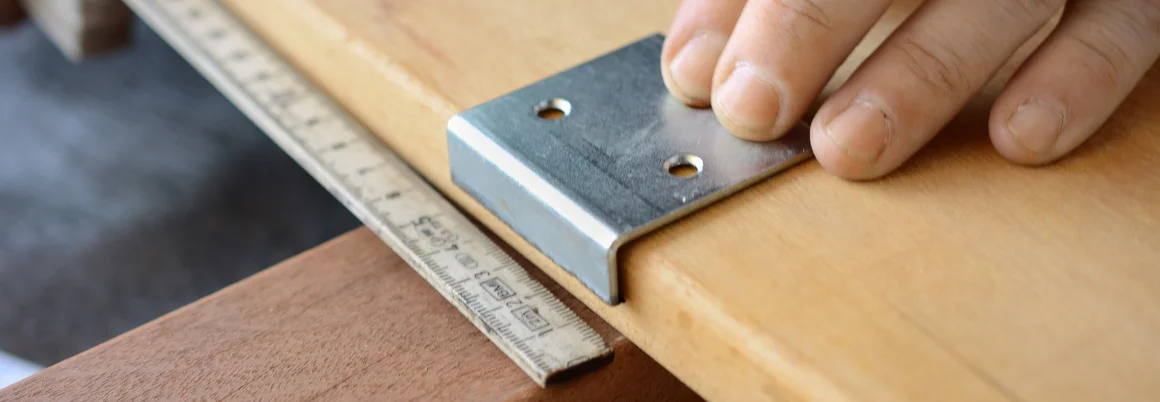 Metallwinkel auf Holzbrett mit Zollstock